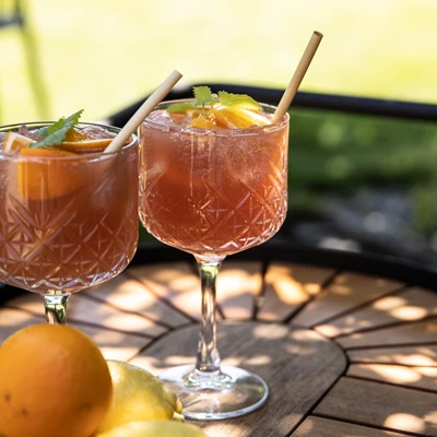 Två glas med drinkar på trädgårdsbord