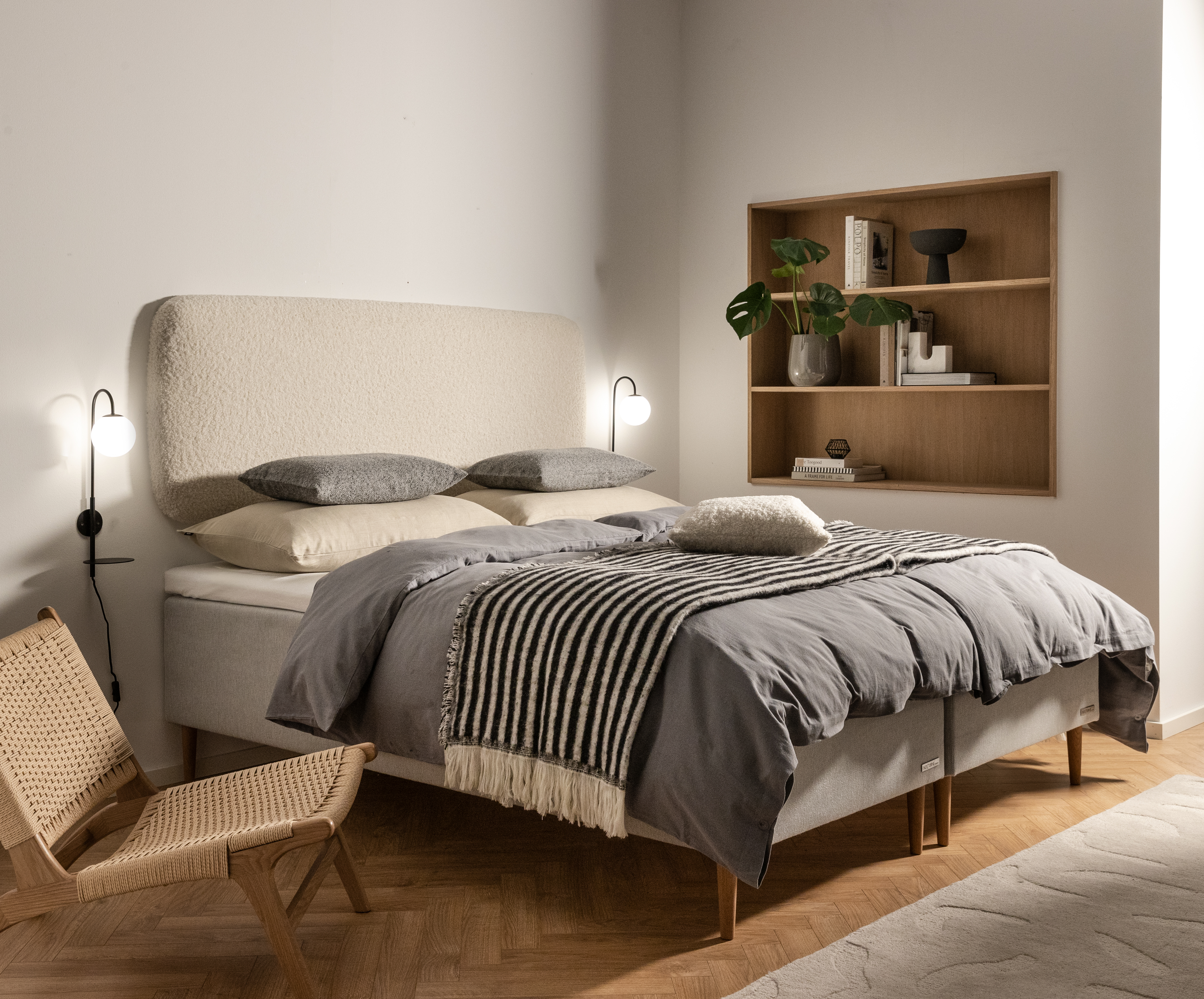 Modernt sovrum med stoppad säng och vägglampor