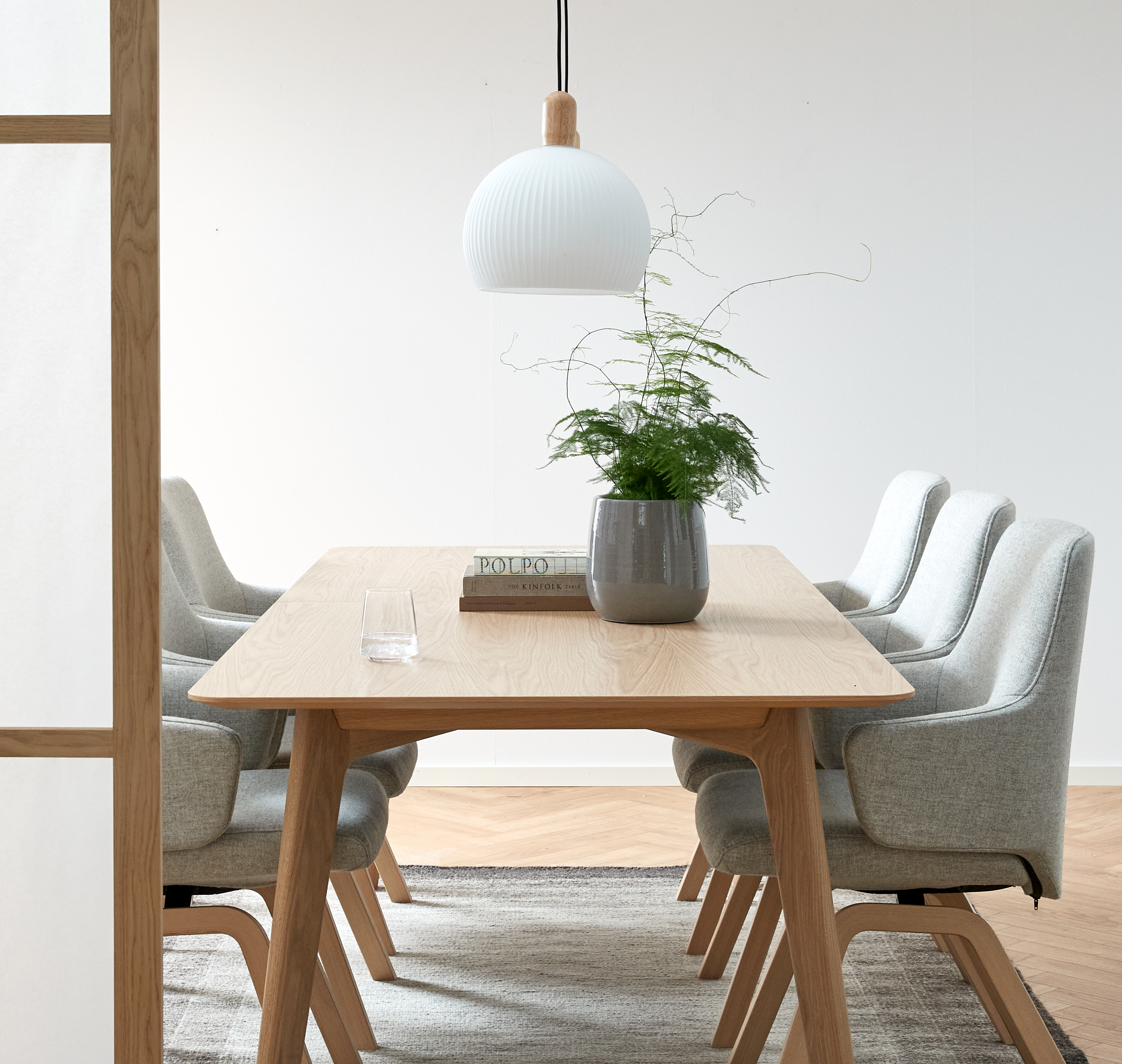 Matsal med ekbord, grå stolar och taklampa