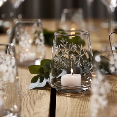 Elegant julbord med glas, ljus och gröna dekorationer
