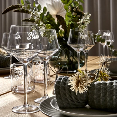Elegant julbord med glas, ljus och gröna dekorationer
