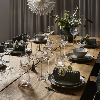 Elegant julbord med glas, ljus och gröna dekorationer