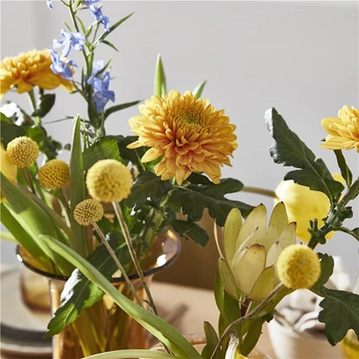 Närbild på gula påskblommor i glasvaser
