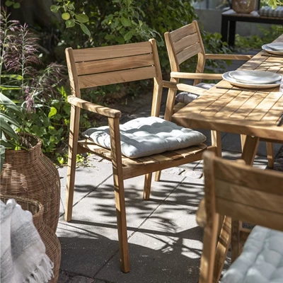 Trädgårdsmöbler i trä med kuddar på terrass