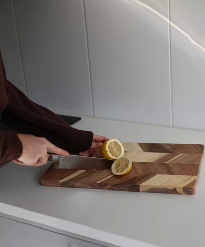 Kvinna skär citron på köksbänk.