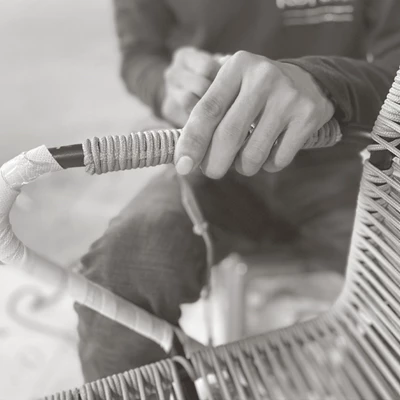 Hantverkare flätar rep runt en stol för hand