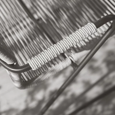 Närbild av en stol med handflätat rep på armstödet