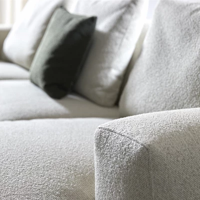 Närbild av ljus soffa med kuddar liggande i.