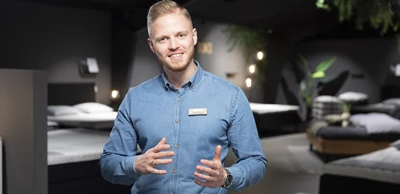 1292x636 rådgiver.jpg Ung kille i blå skjorta som gestikulerar med händerna och ler.