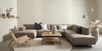 Modern vardagsrum med hörnsoffa och naturliga färgtoner