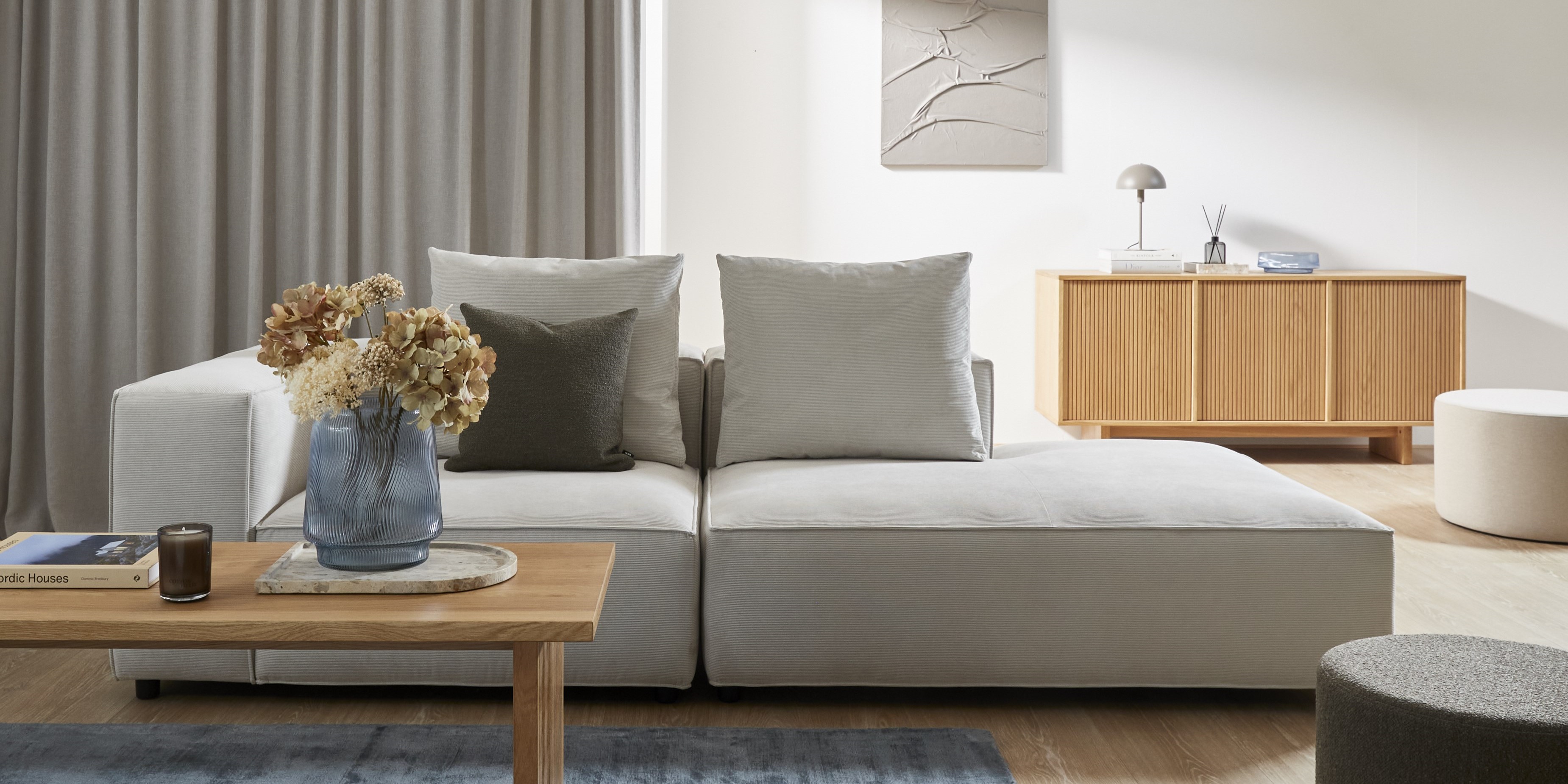 Ljus soffa med open end i ett ljust minimalistiskt vardagsrum.