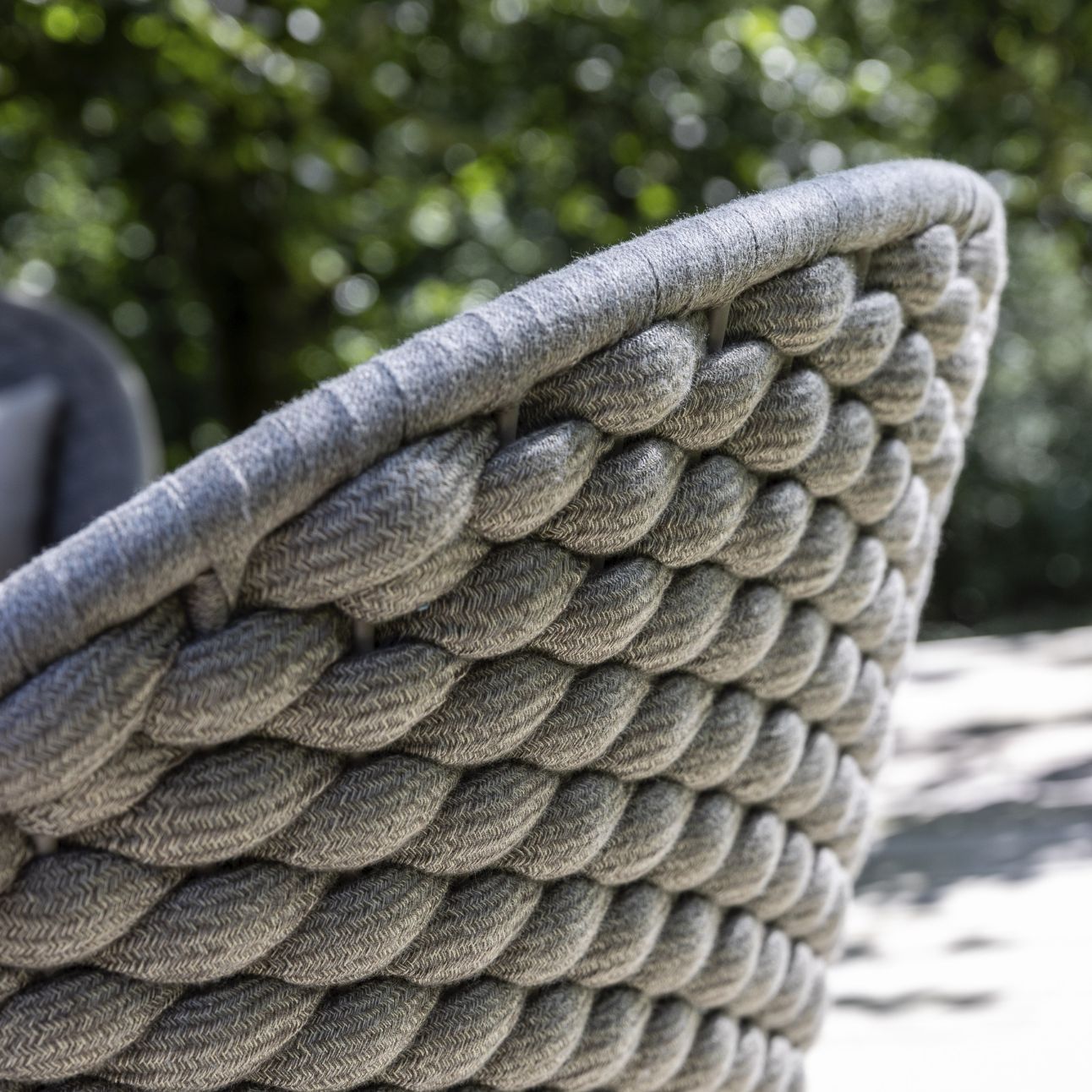 Närbild av grovt vävt ryggstöd på en modern utomhusstol.