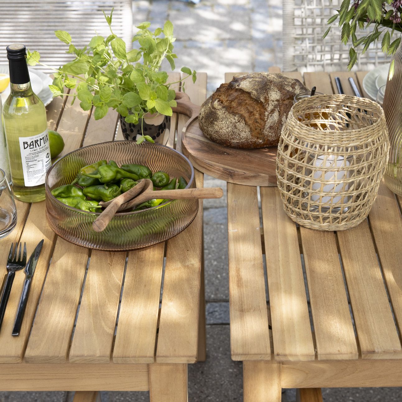 Närbild av ett träbord täckt med matvaror som bröd och skålar med frukter och grönsaker.