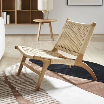 Trästol med flätad sits på en färgglad matta