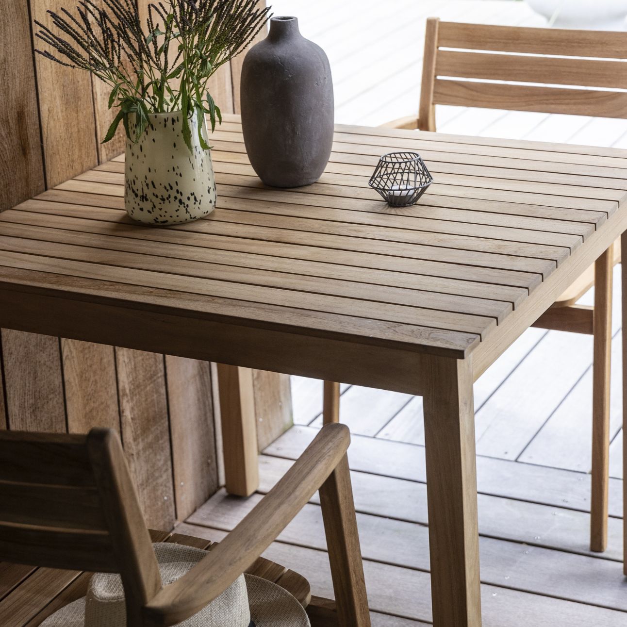 Närbild av träbord med två stolar och vaser på bordet