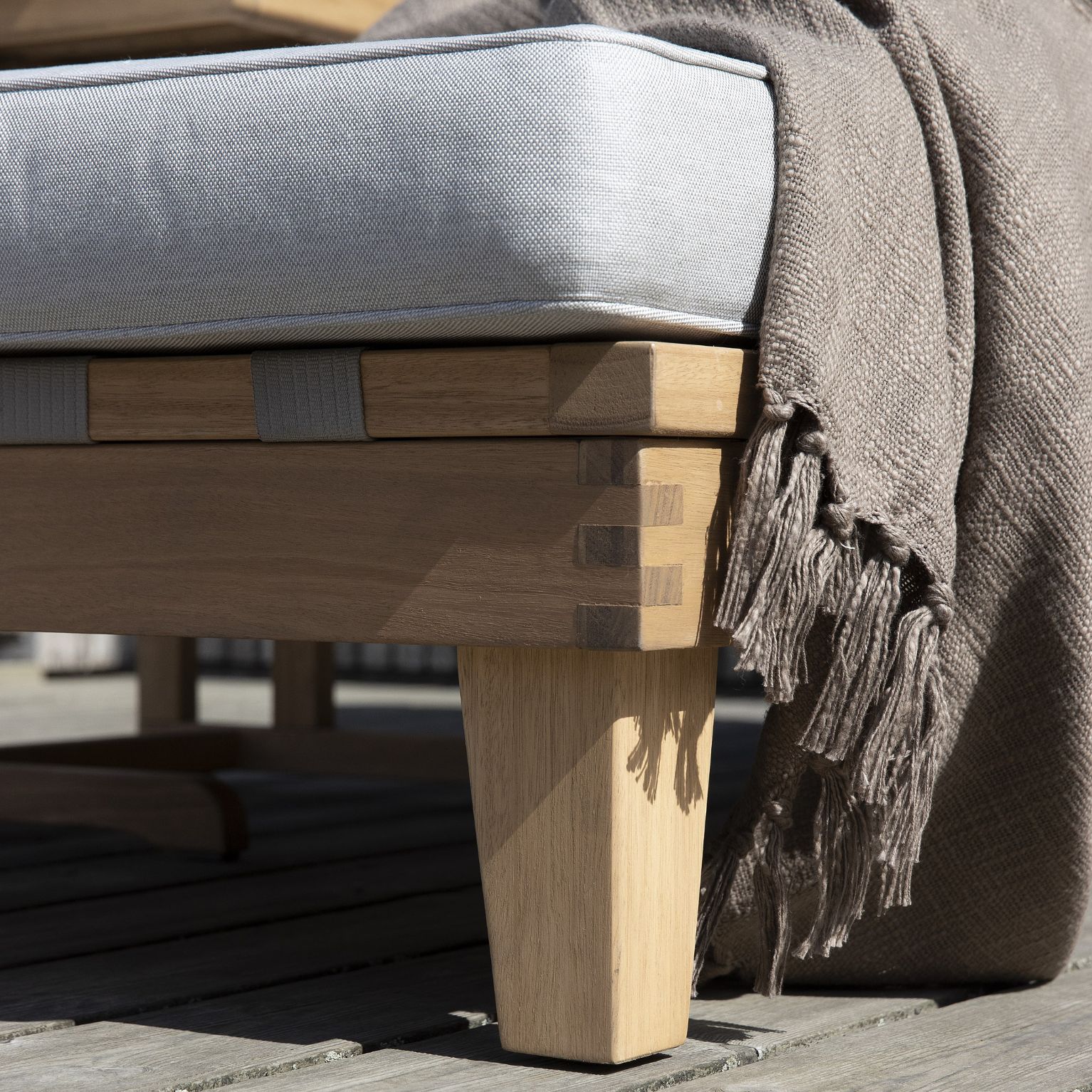 Detaljerad bild av benen på en solsäng i eukalyptusträ.