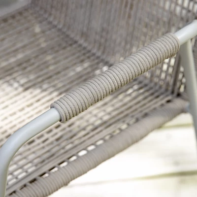 Närbild av armstöd och säte på en trädgårdsstol som består av polyesterflätning