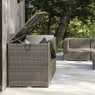 Dynlåda i polyrattan med öppet lock på träterrass.