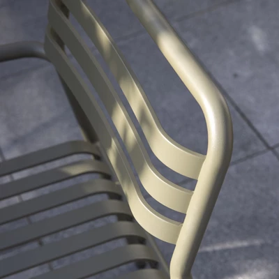 Närbild av ryggstöd på caféstol i grön aluminium.