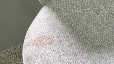 Rödaktig fläck på grått textil