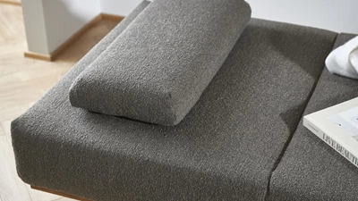 Daybed i mörkgrå design med kudde ovanpå