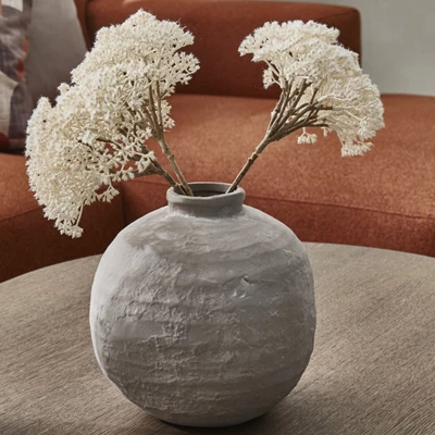 Grå och rund terrakottavas med vita blommor i.