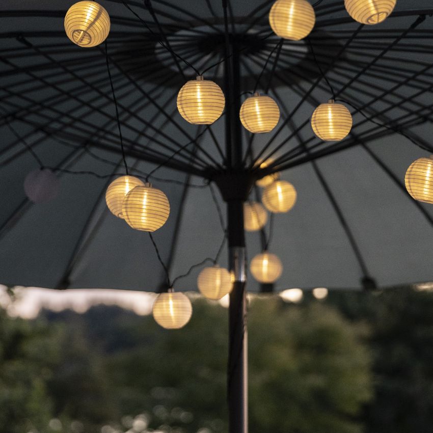 Ljusslinga med solceller placerad i toppen av insidan på en parasoll.