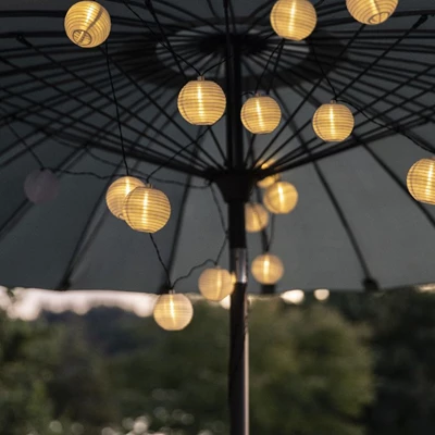 Ljusslinga med solceller placerad i toppen av insidan på en parasoll.