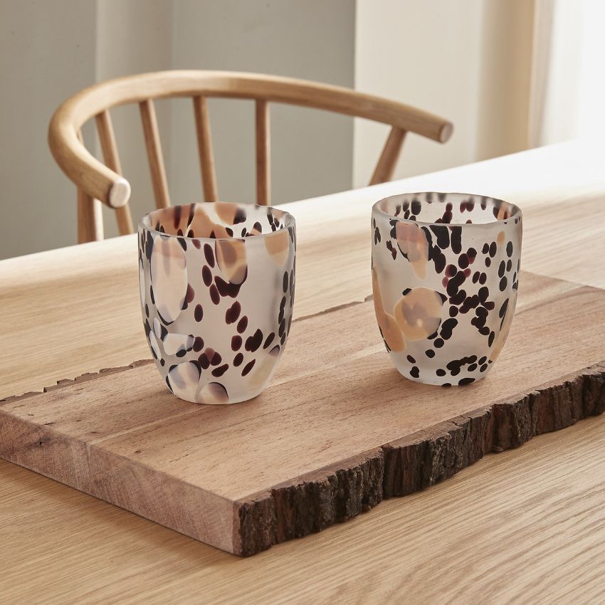 2 glas på matbord med brunaktigt, svart och vitaktigt mönster.