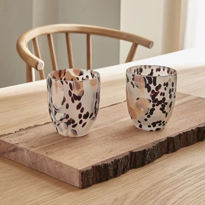 2 glas på matbord med brunaktigt, svart och vitaktigt mönster.