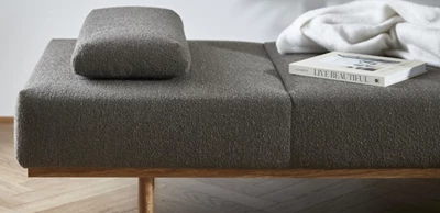 Daybed i mörkgrå design med kudde liggande ovanpå