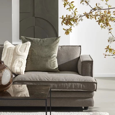 Halva soffan i Soil-tyg stående vid soffbord i svart metall och vit matta