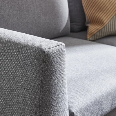 Närbild av armstöd på soffa i Rate-textil i gråaktig färg