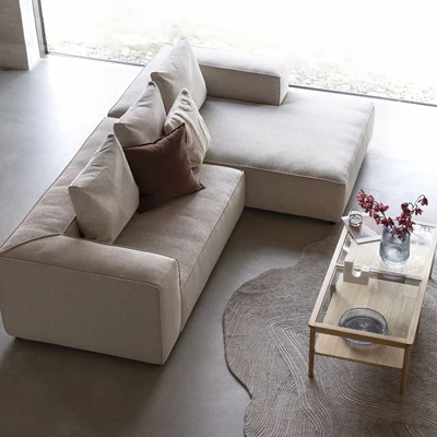 Sandfärgad modulsoffa sedd uppifrån i minimalistisk inredning