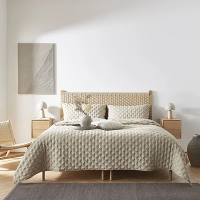 Uppbäddad säng i sovrum i beige och sandfärger