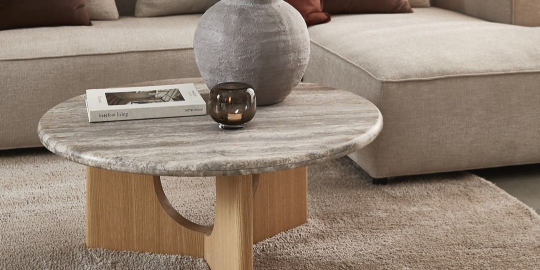 Runt soffbord med bok, vas och ljusstake