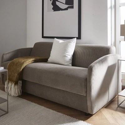 Bäddsoffa i brun/grått tyg med filt och kudde