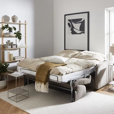 Utslagen och bäddad bäddsoffa med täcken