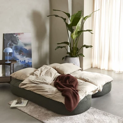 Utslagen och bäddad bäddsoffa med täcken ovanpå