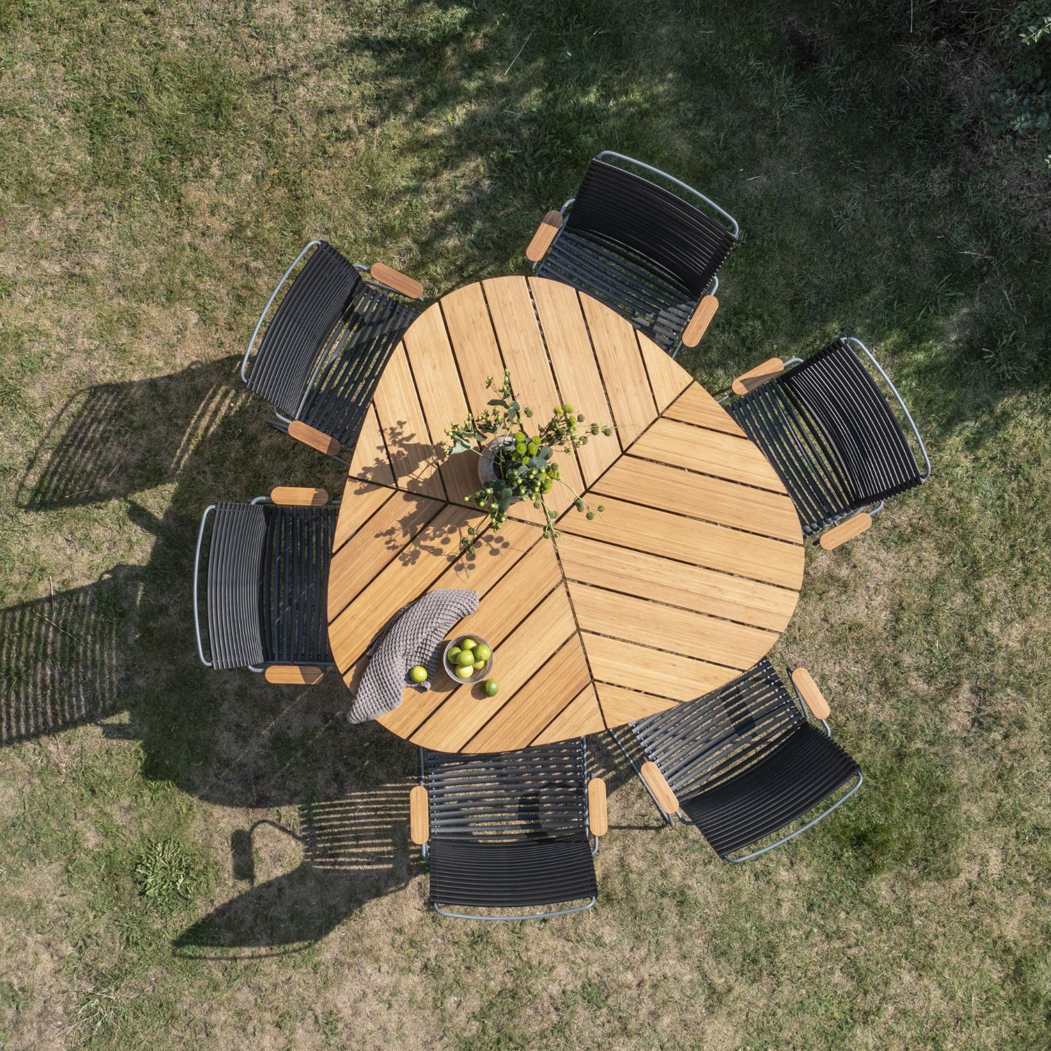 Utebord i bambu formad som ett blad med 6 trädgårdsstolar runtom