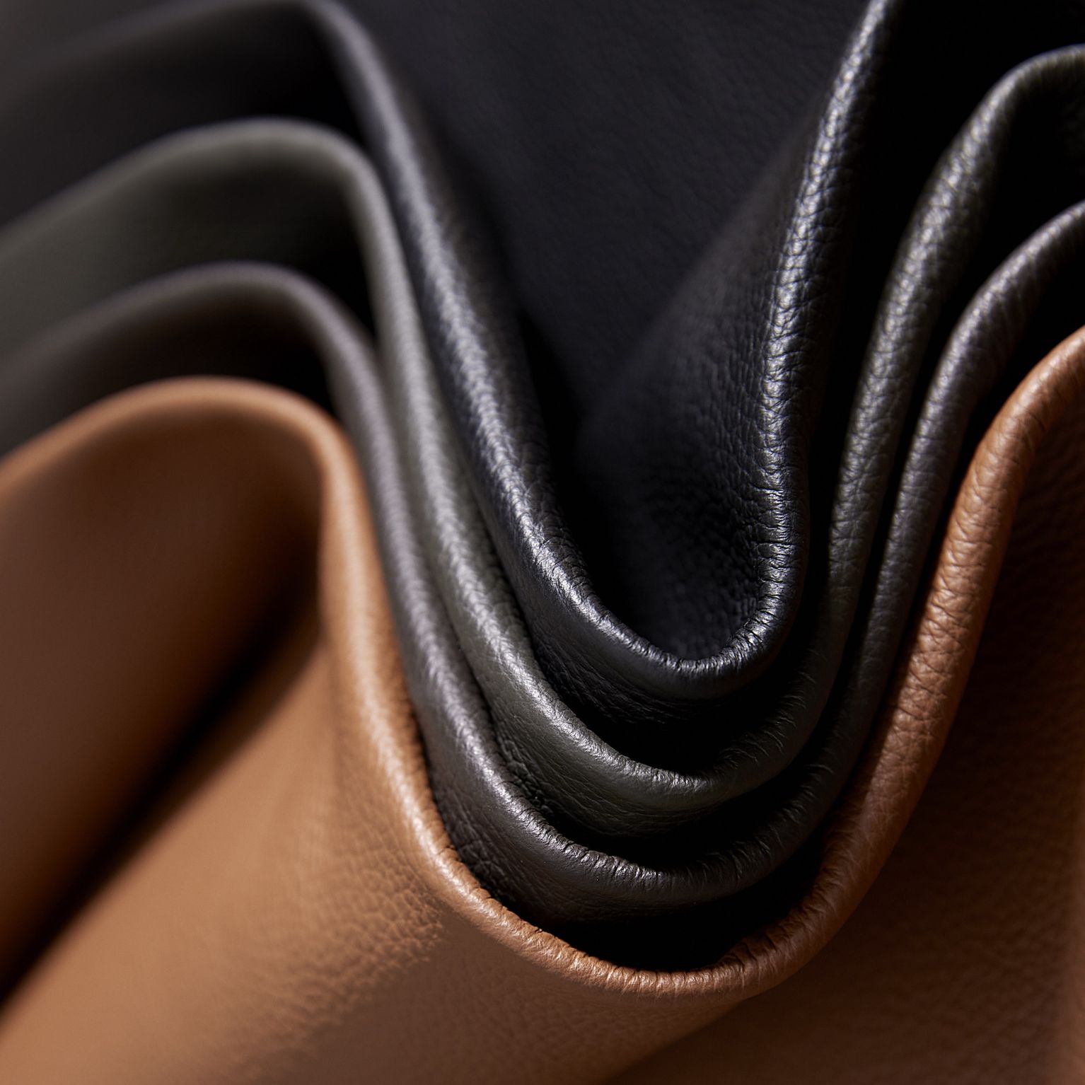 Läderprover i olika nyanser från brunt till svart liggande vikta ovanpå varandra