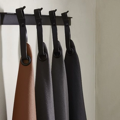 Fyra läderprover hängande med rem på klädhängare