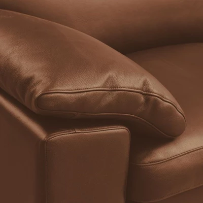 Närbild av armstöd i cognacbrunt läder