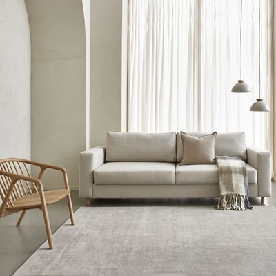 Ljus sovesofa i ett ljust rum.