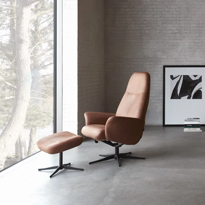 Fåtölj med pall i brunt läder.