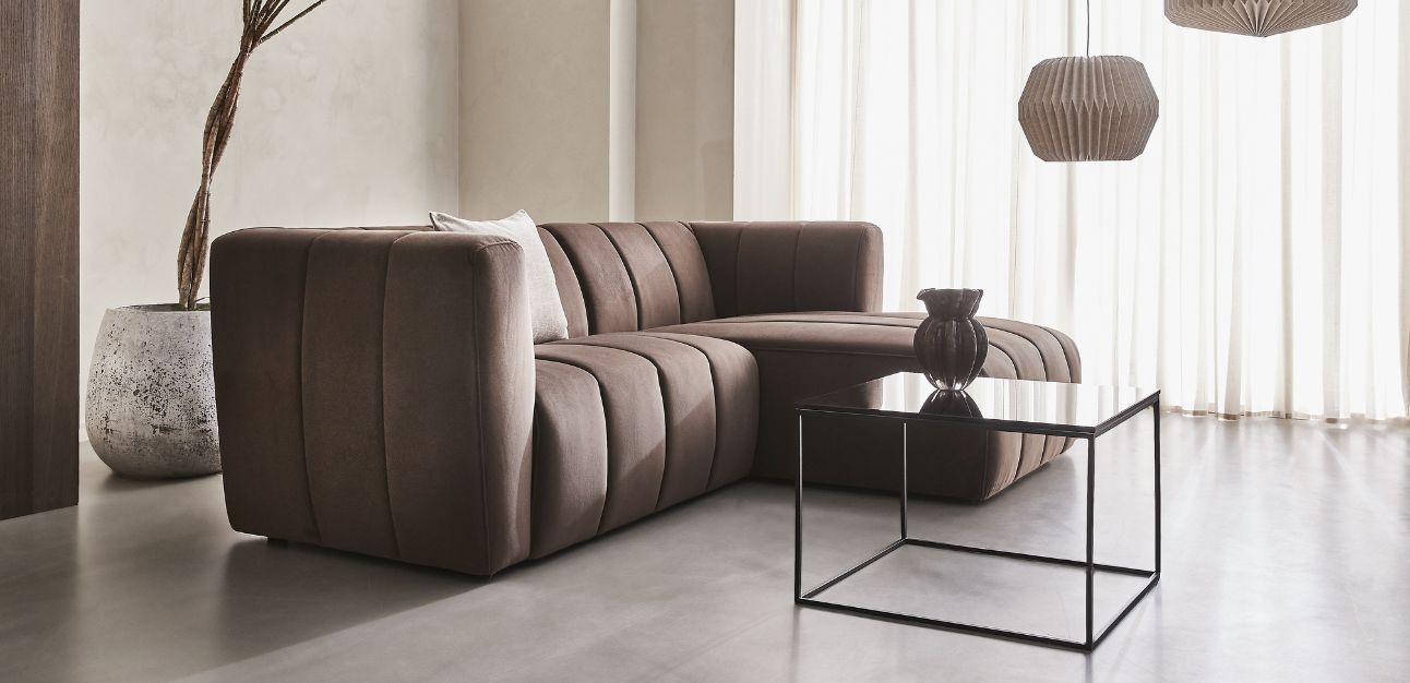 Brun modulsoffa och svart soffbord i ljust vardagsrum