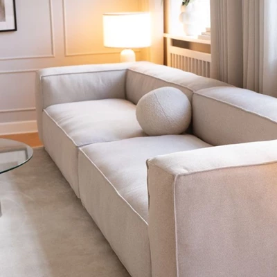Nordstrom modulsoffa stående på vardagsrumsgolvet på en vit matta i ett vardagsrum med paneler på väggarna