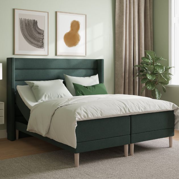 Grön kontinentalsäng med sänggavel i sovrum