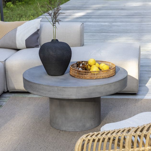 Lounge trädgårdsbord i fiberbetong med citroner och en svart vas ovanpå