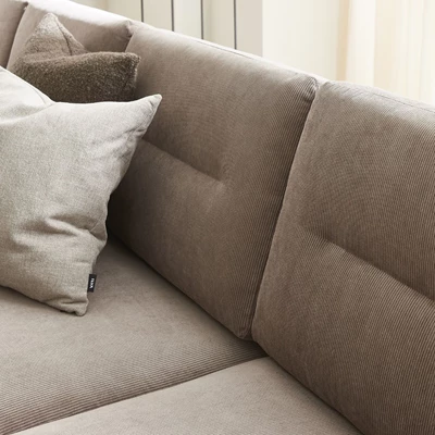 Närbild av ryggkuddar på grå soffa